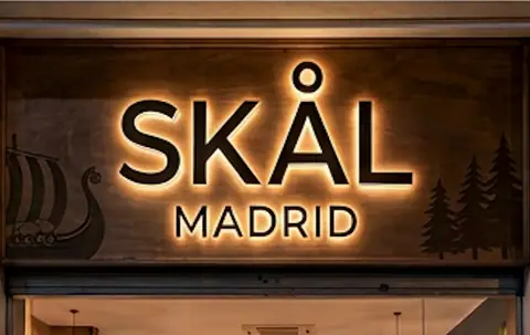 Fachada de SKÅL Madrid con el rótulo retroiluminado y las siluetas de un drakkar y unos abetos