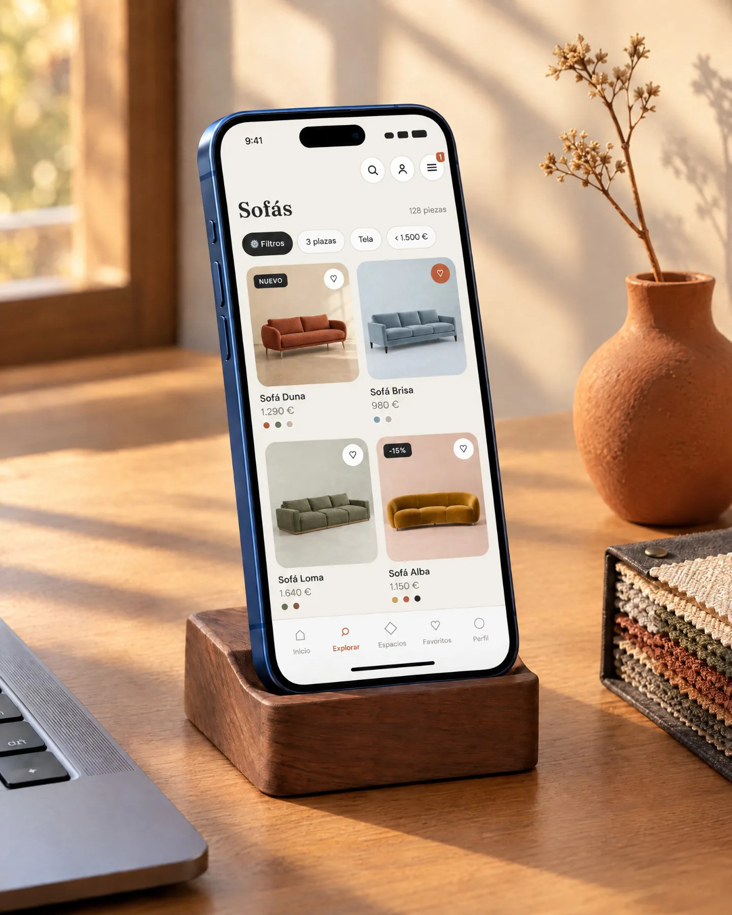 An iPhone on a walnut stand on the desk showing Olmo's sofa list